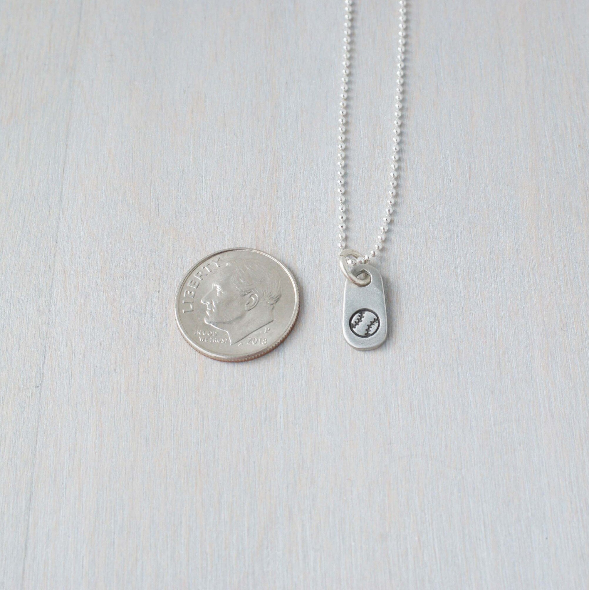 Silver baseball necklace in artisan pewter next to dime