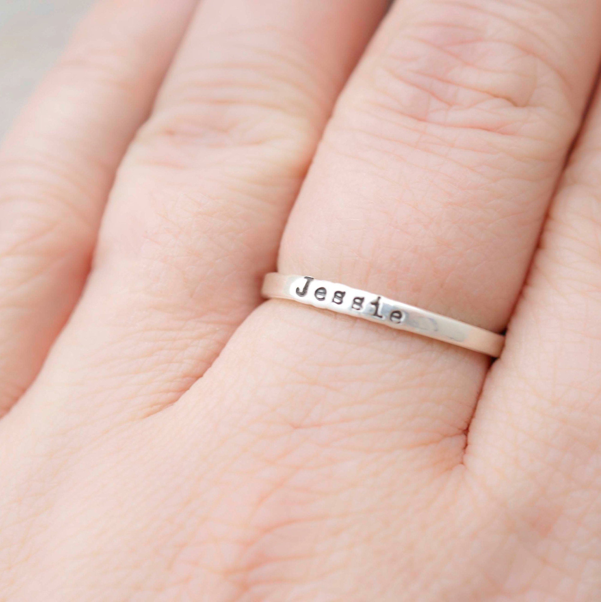 Sterling silver ring stamped with a personalized name on hand