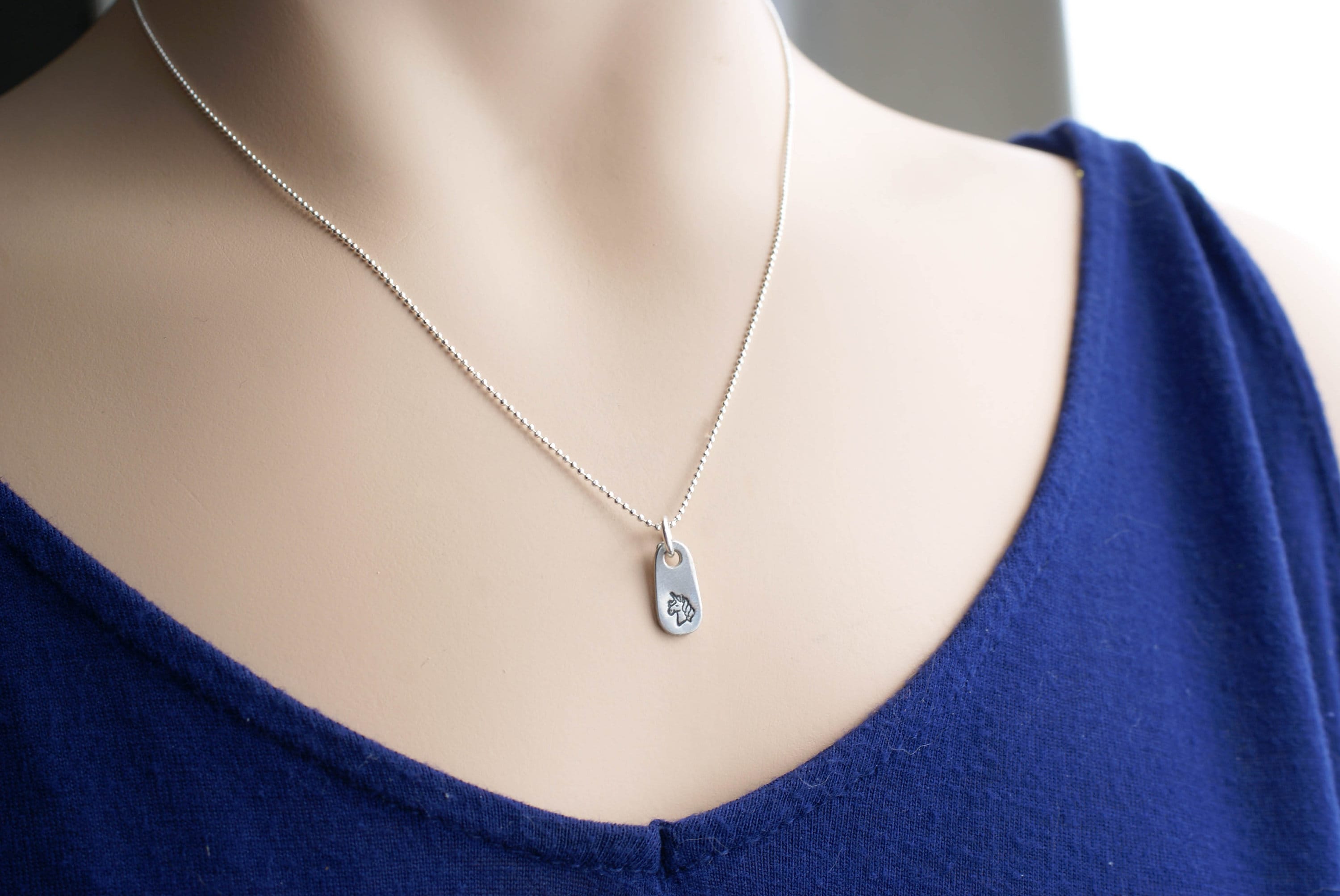 Silver unicorn necklace in artisan pewter on neck