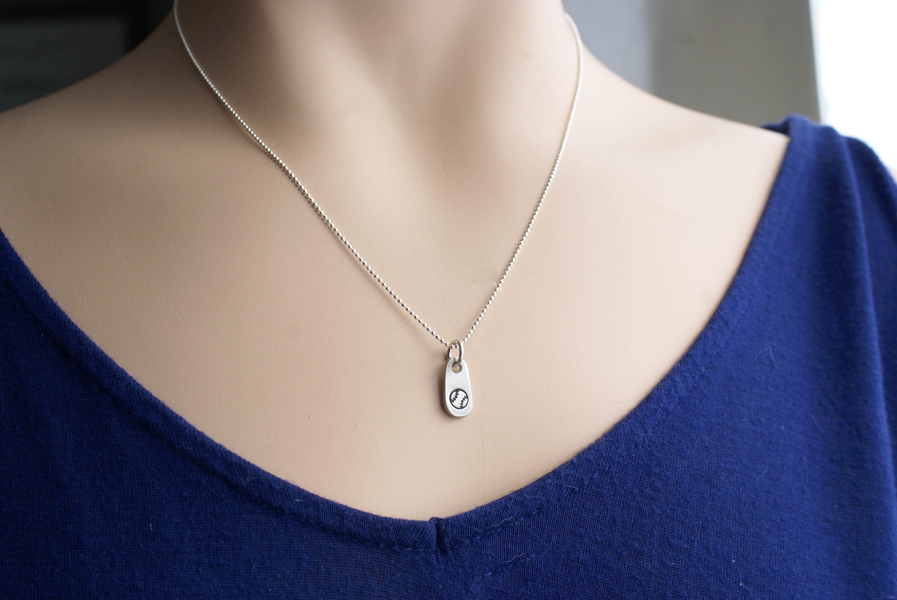 Silver softball necklace in artisan pewter on neck