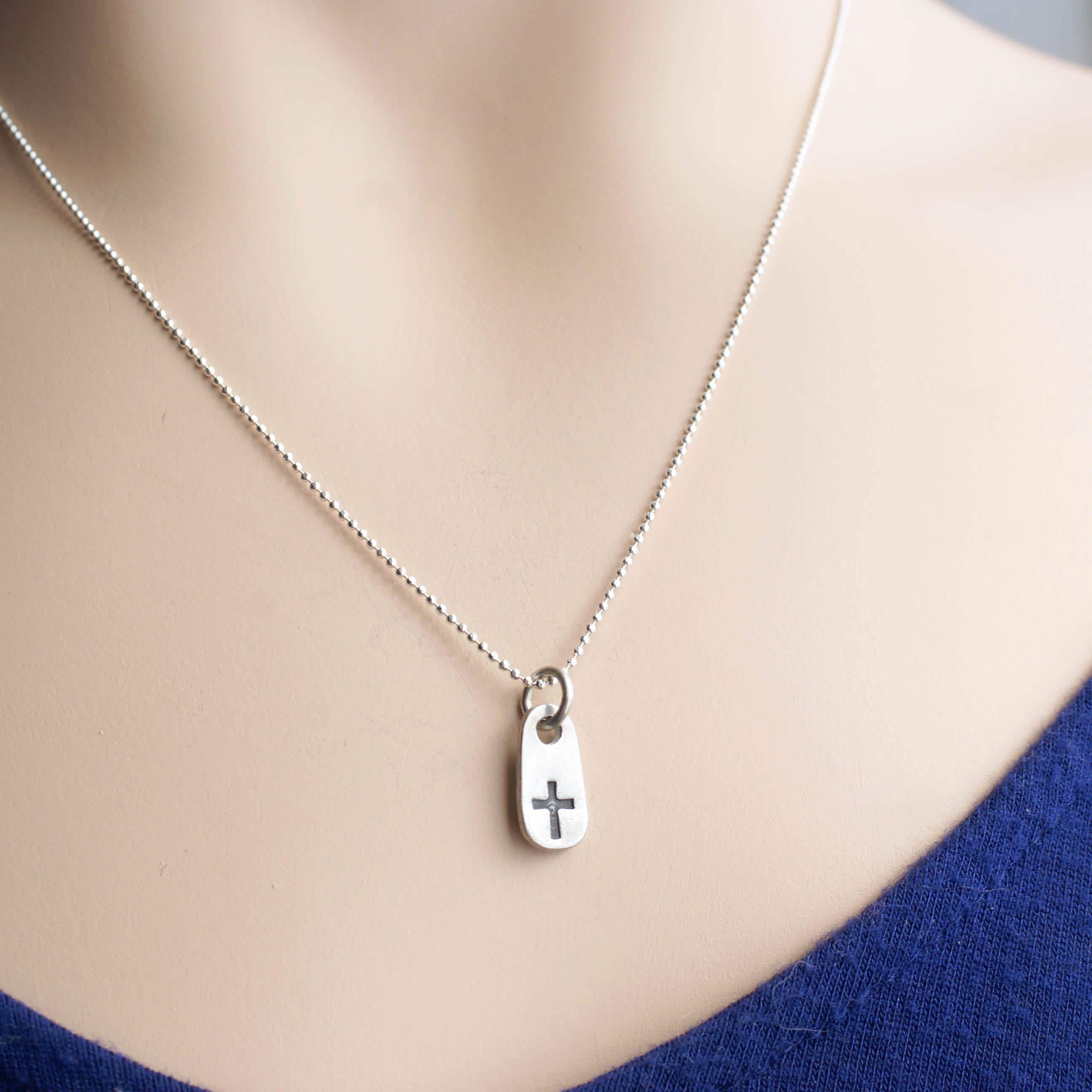 image of dainty cross necklace on neck