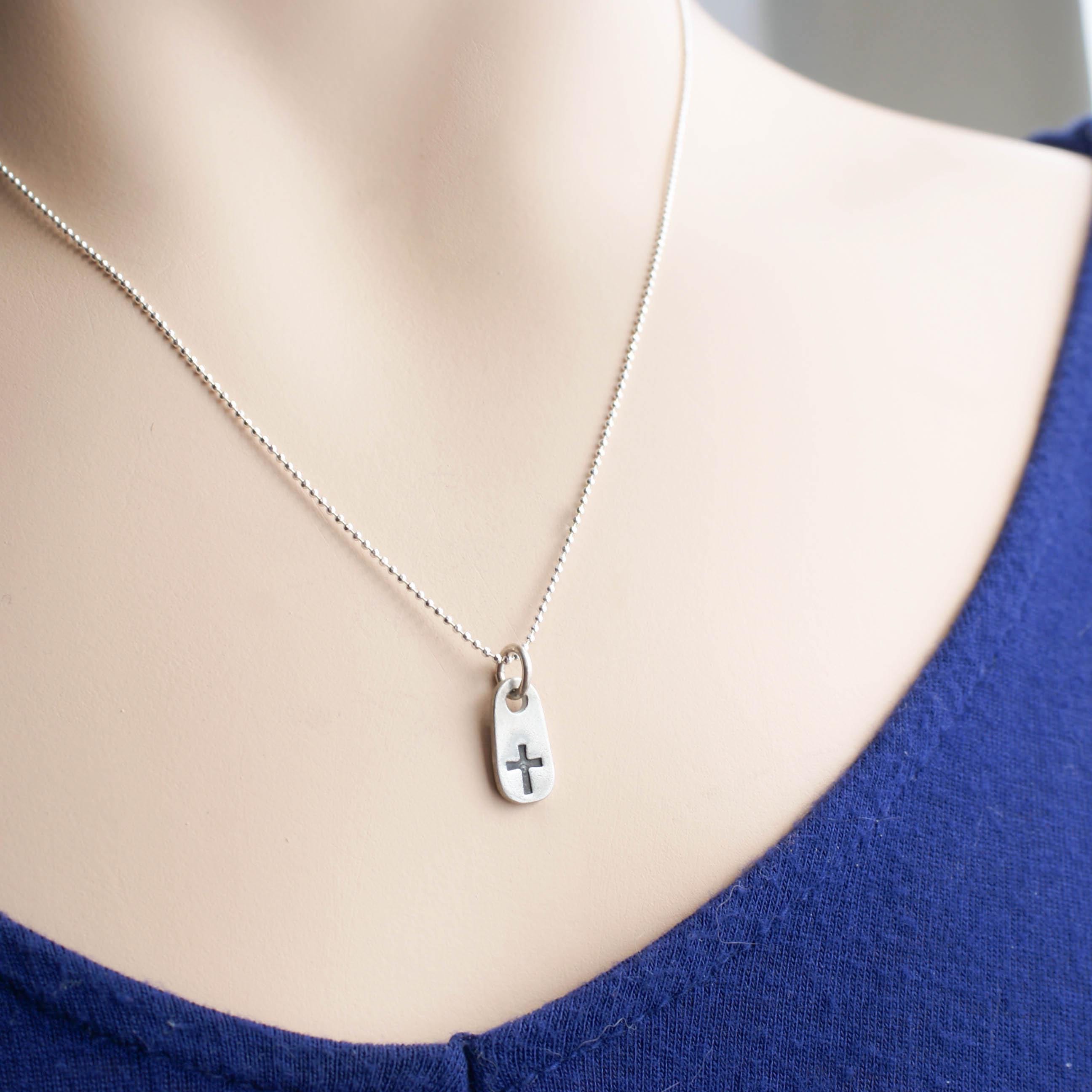 image of small cross necklace on neck