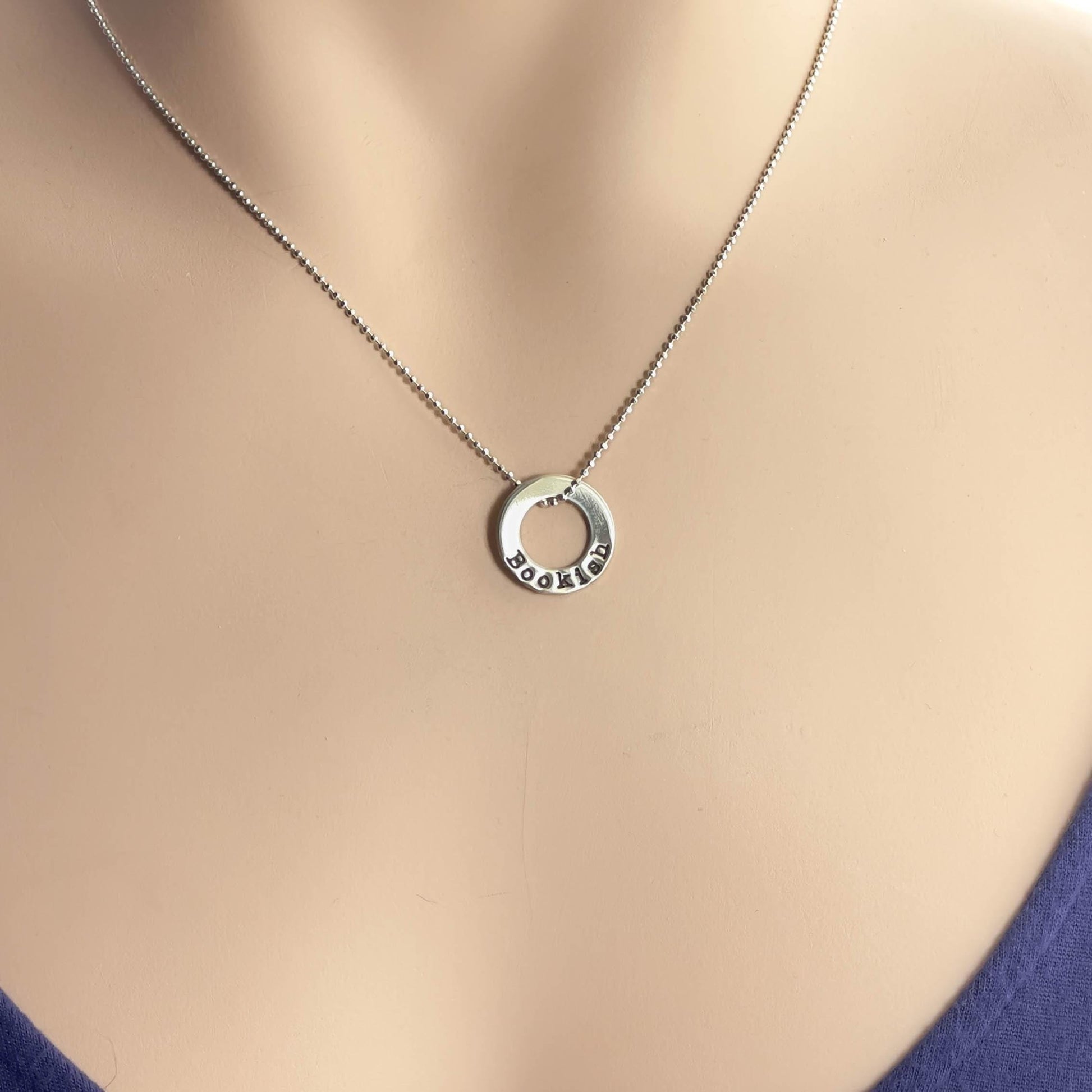image of bookish sterling silver necklace on a neck