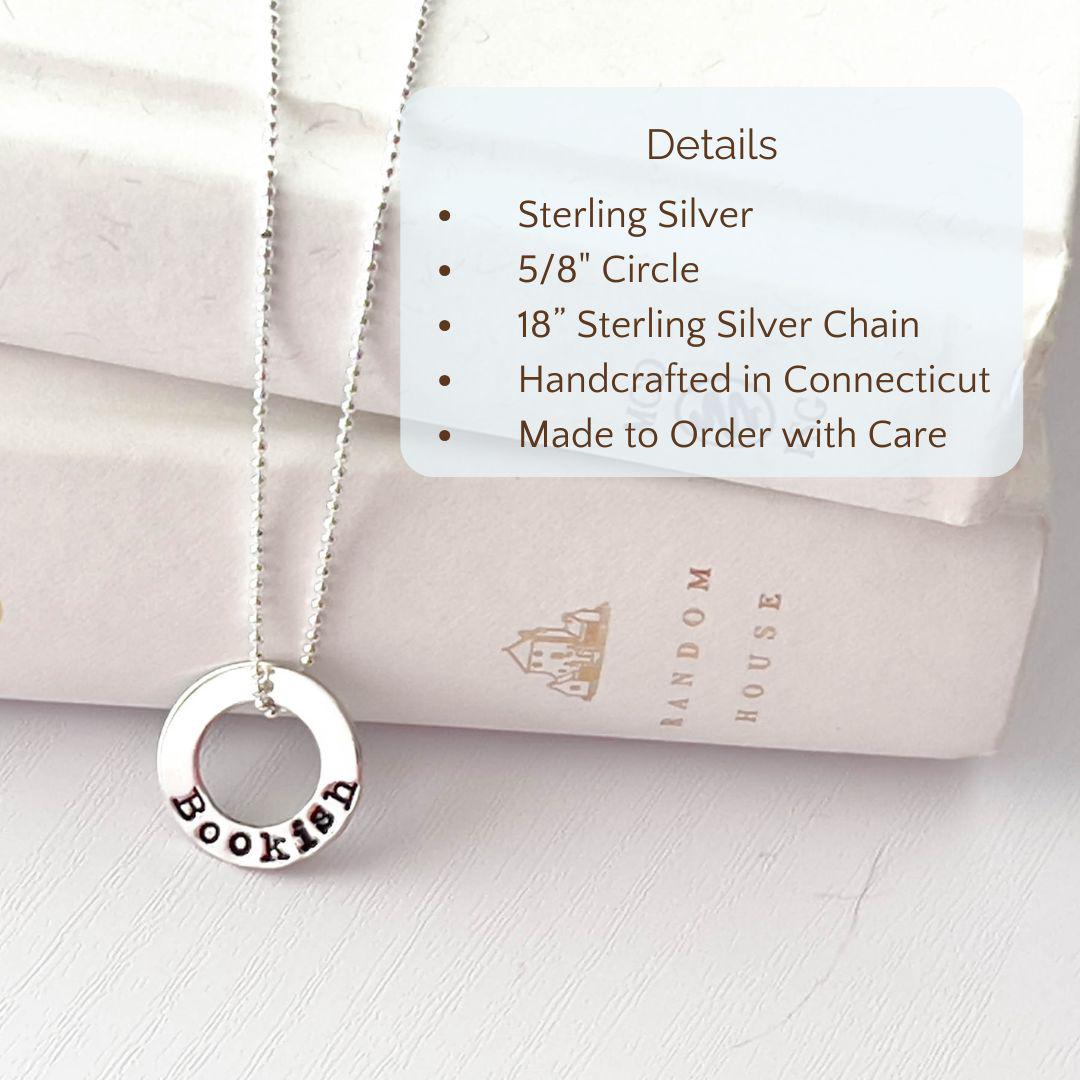 image of bookish sterling silver necklace leaning against books with product details overlayed