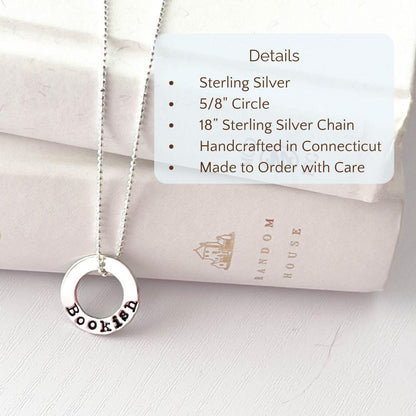 image of bookish sterling silver necklace leaning against books with product details overlayed