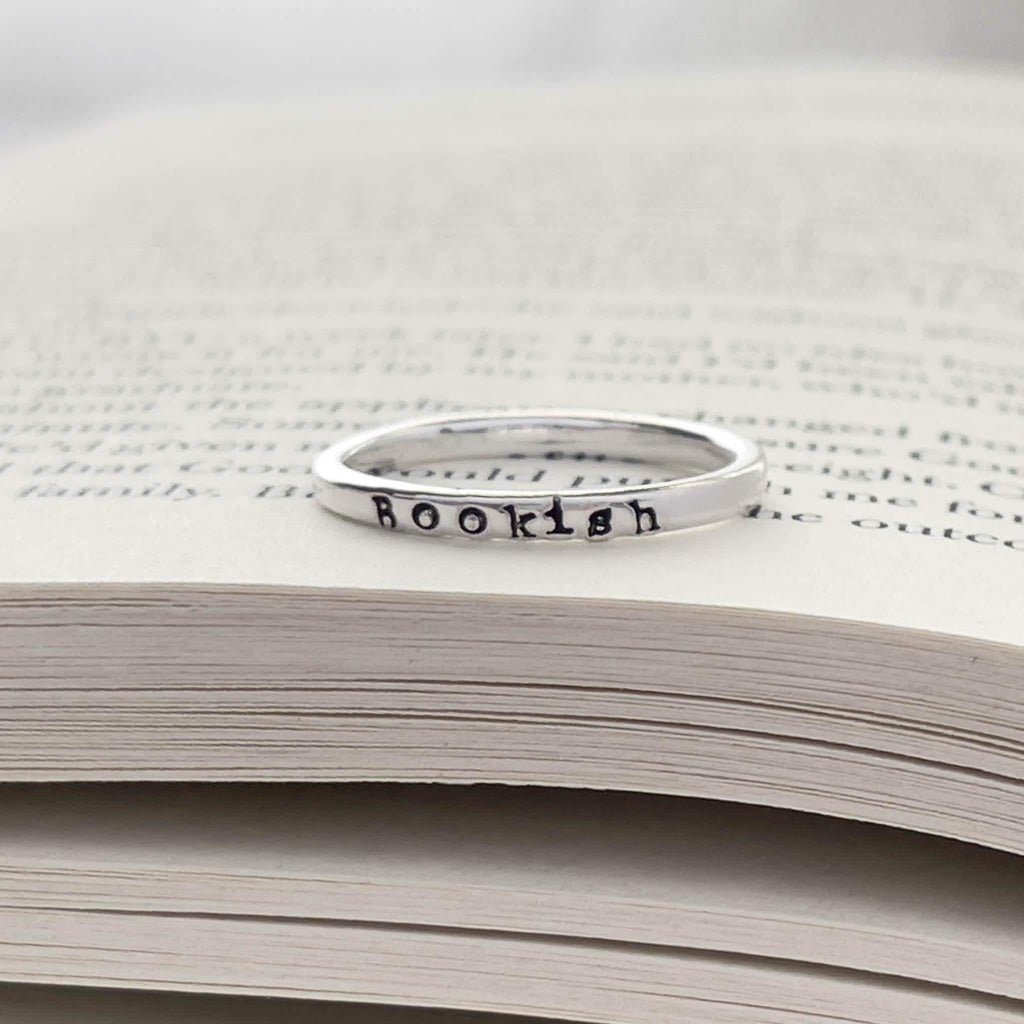 image of sterling silver bookish necklace on a book