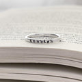 image of sterling silver bookish necklace on a book