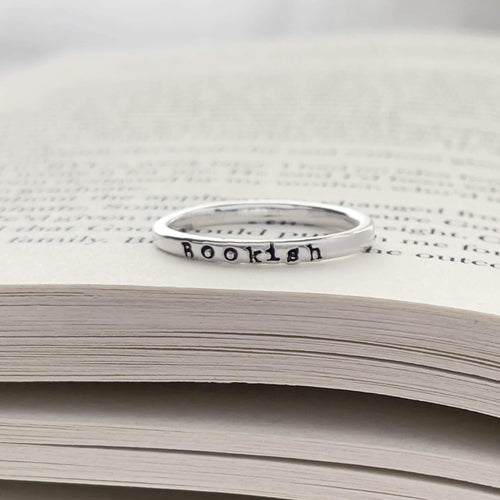image of sterling silver bookish necklace on a book