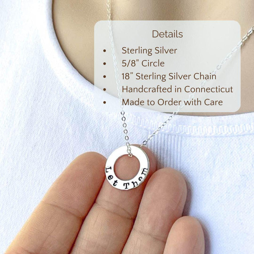 Sterling Silver Necklace stamped with Let Them held in hand on white background with detail text.