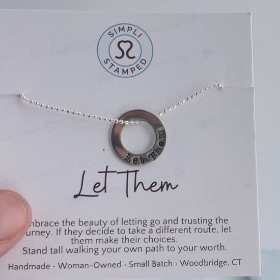 Video of Let Them Necklace being held on  inspirational card in hand