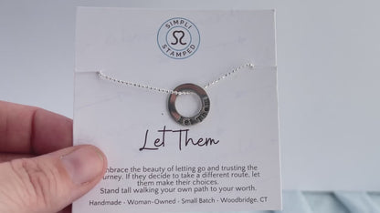 Video of Let Them Necklace being held on  inspirational card in hand