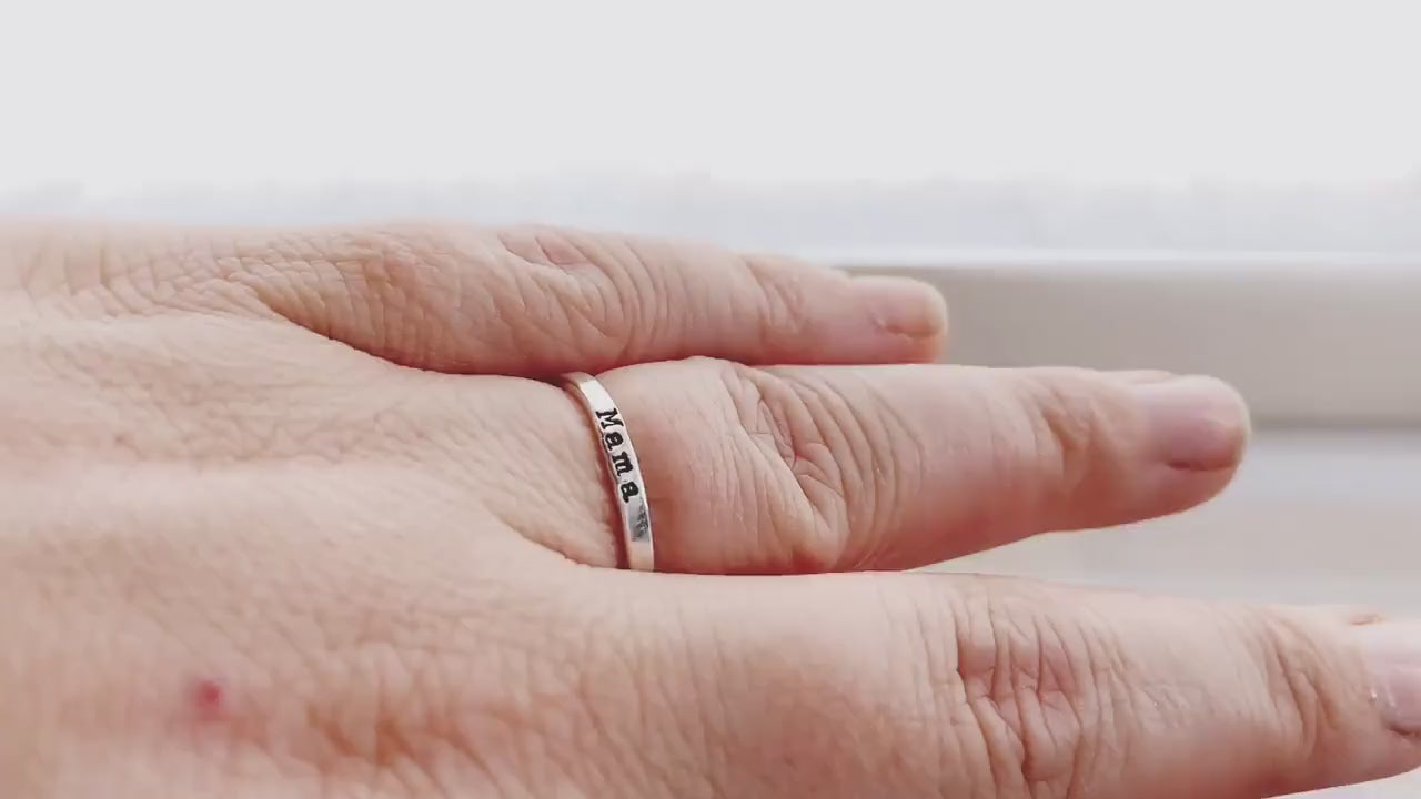 Sterling silver ring handstamped with Mama on hand and being held