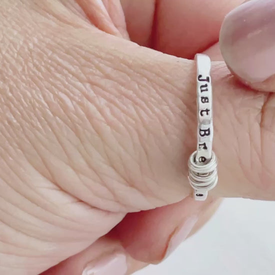 Just Breathe anxiety sterling silver ring on a hand