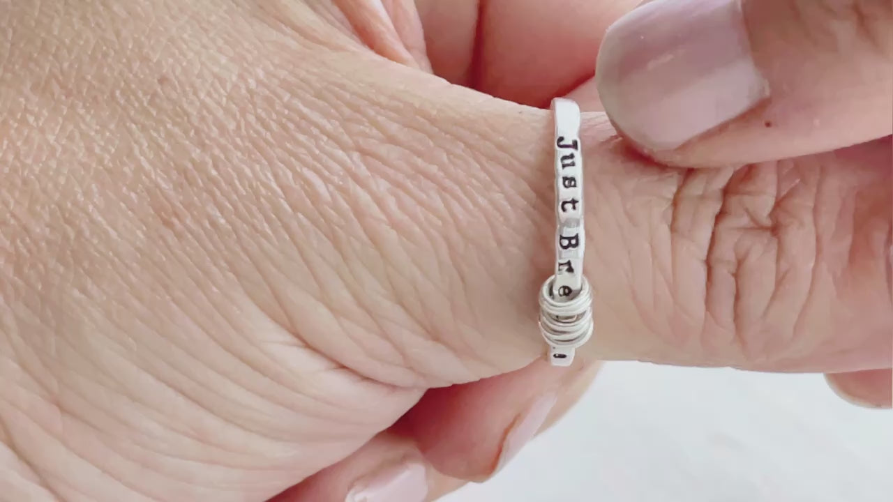 Just Breathe anxiety sterling silver ring on a hand