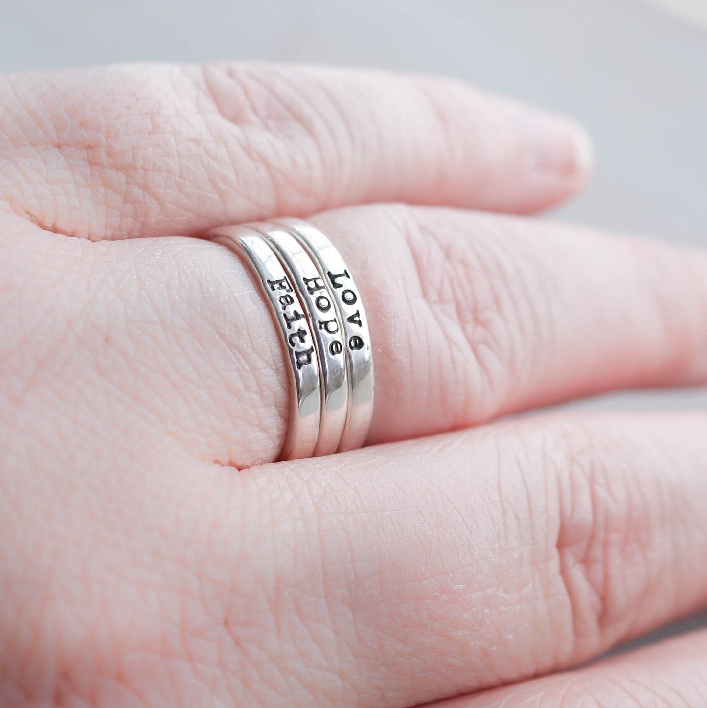 3 Sterling silver rings stamped with Faith, hope and love on hand