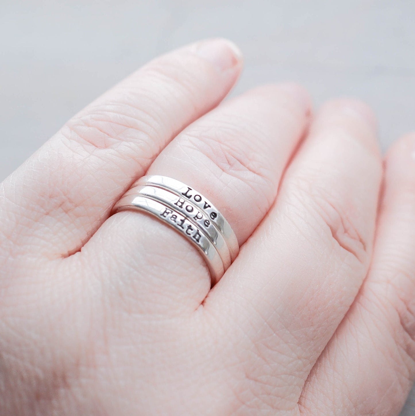 3 Sterling silver rings stamped with Faith, hope and love on hand