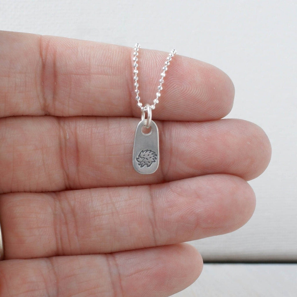 Silver hedgehog necklace in artisan pewter in hand
