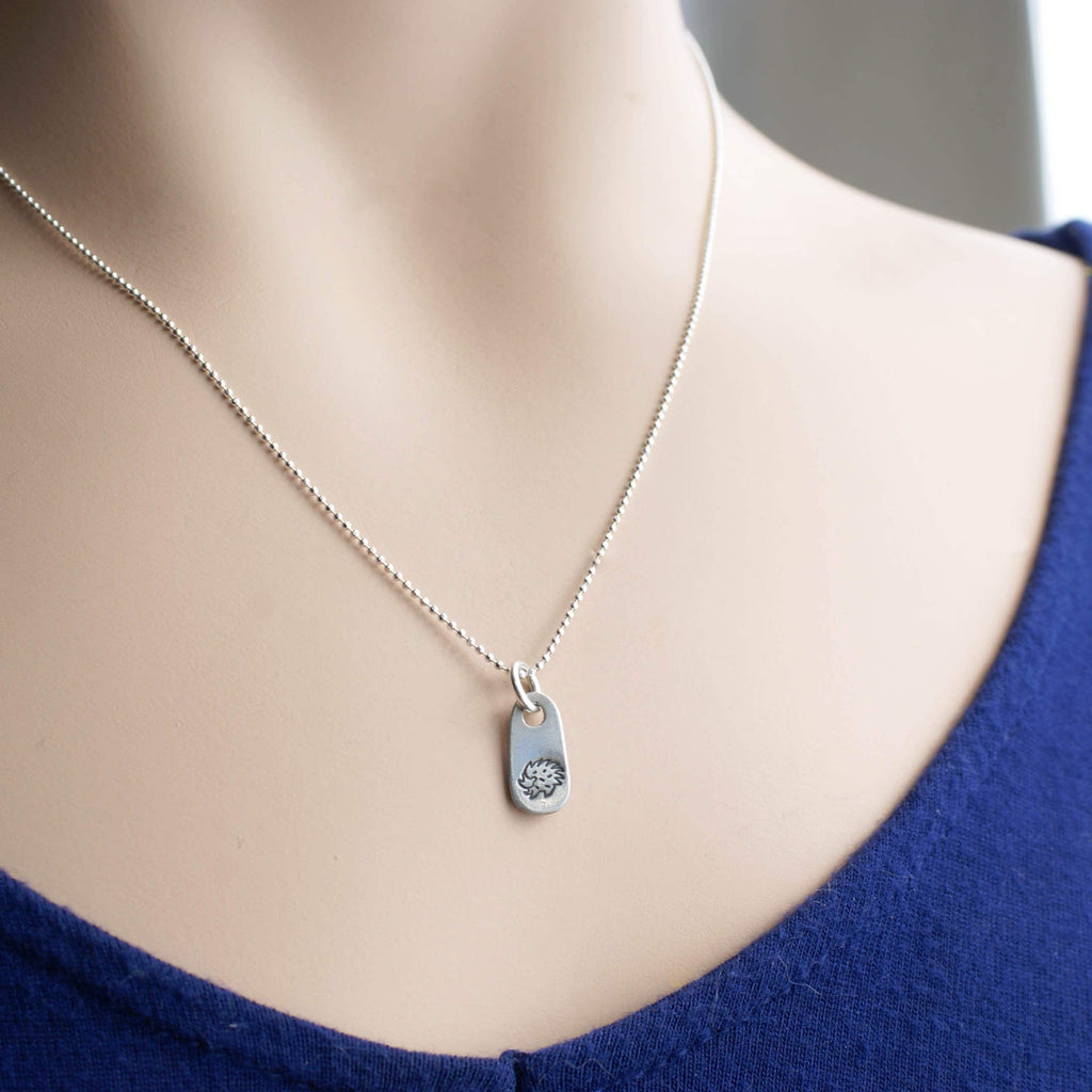 Silver hedgehog necklace in artisan pewter on neck