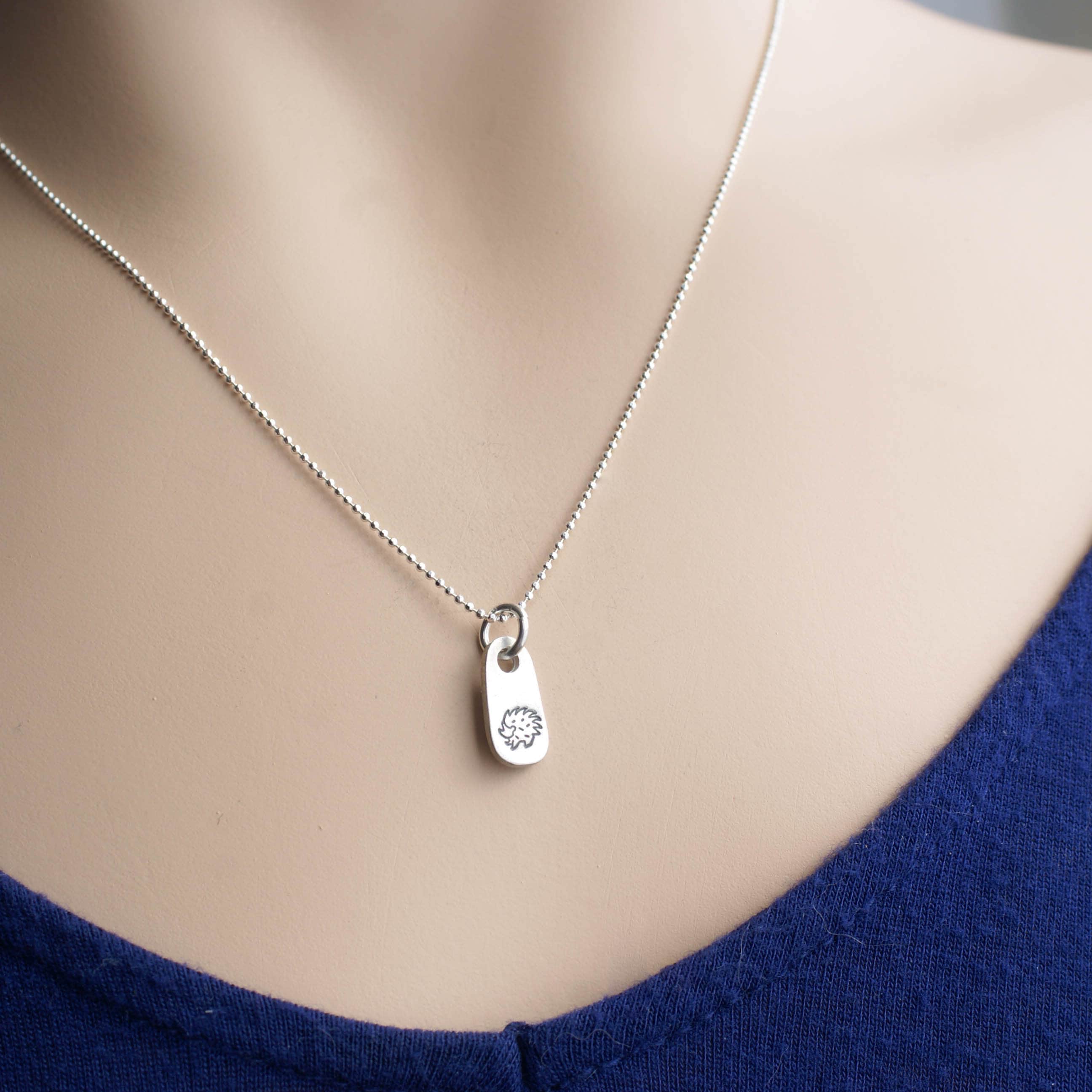 Silver hedgehog necklace in artisan pewter on neck