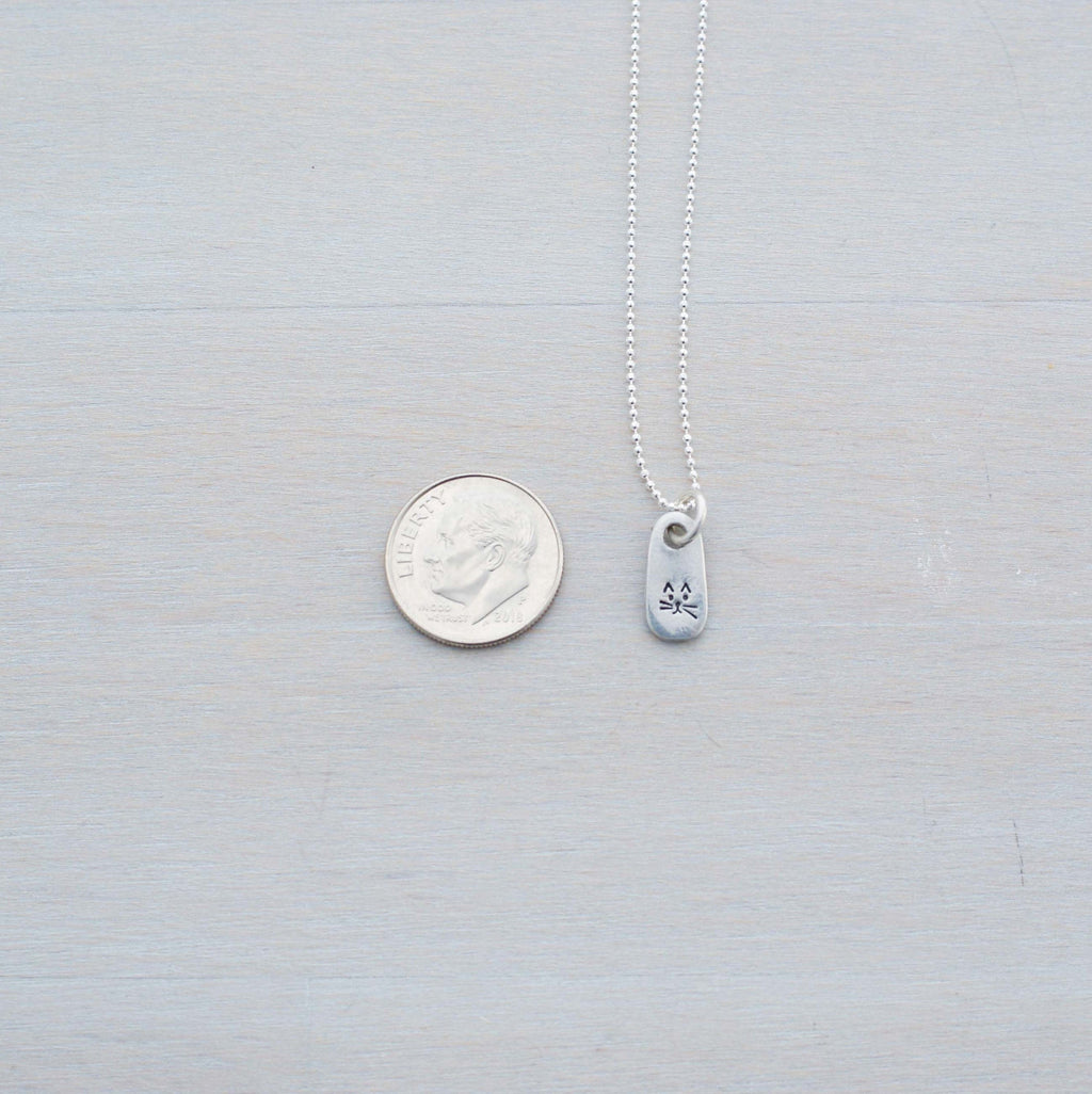 Petite Silver Necklace in Artisan Pewter with handstamped kitty face next to dim