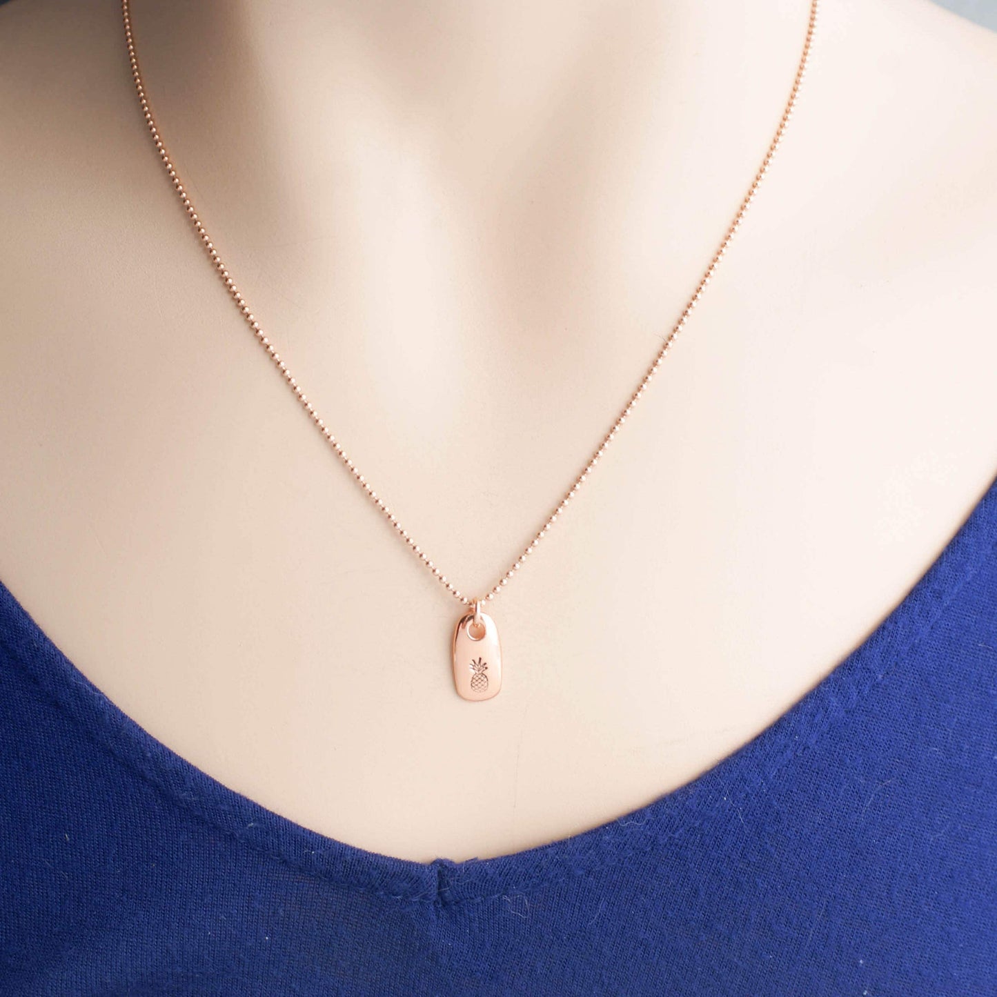 Dainty rose gold pineapple necklace on neck