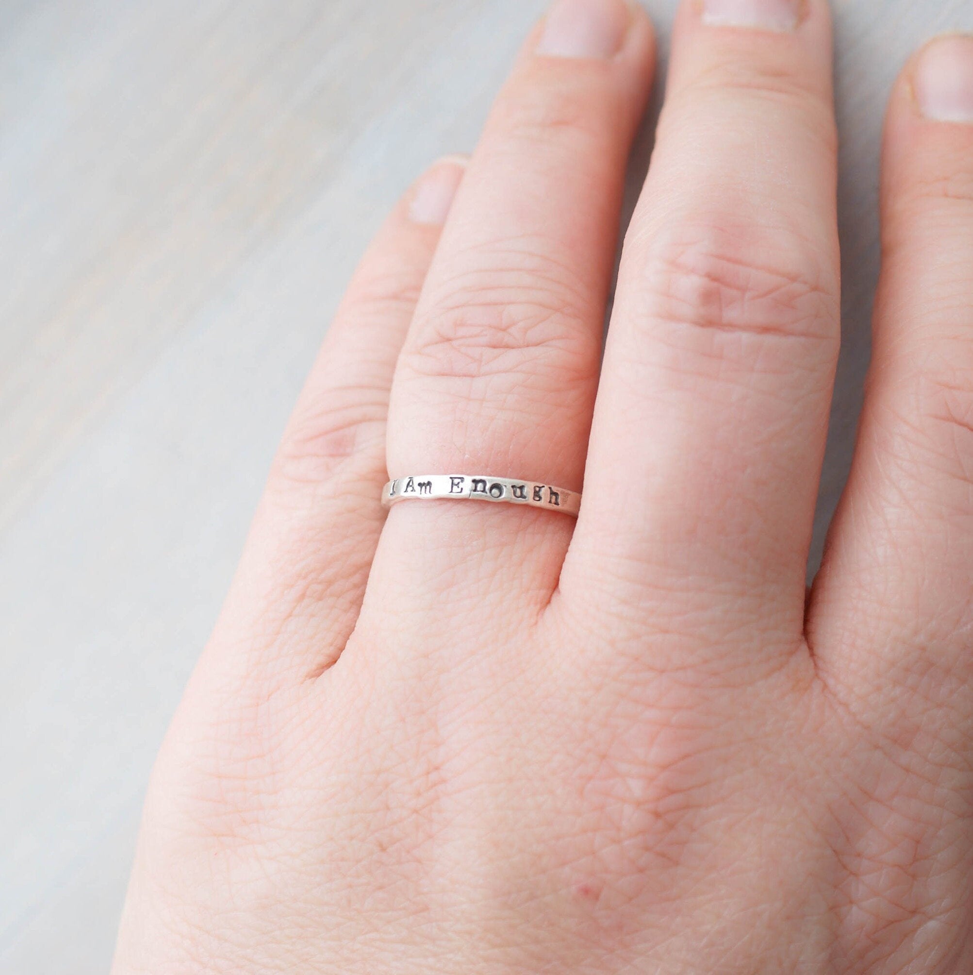 Sterling Silver stacking ring handstmaped with I Am Enough on hand