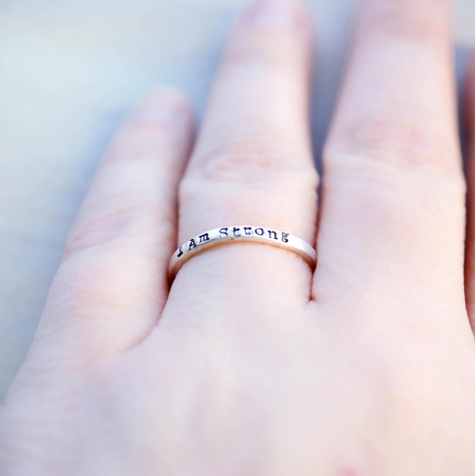 Sterling Silver stacking ring handstmaped with I Am Strong on hand