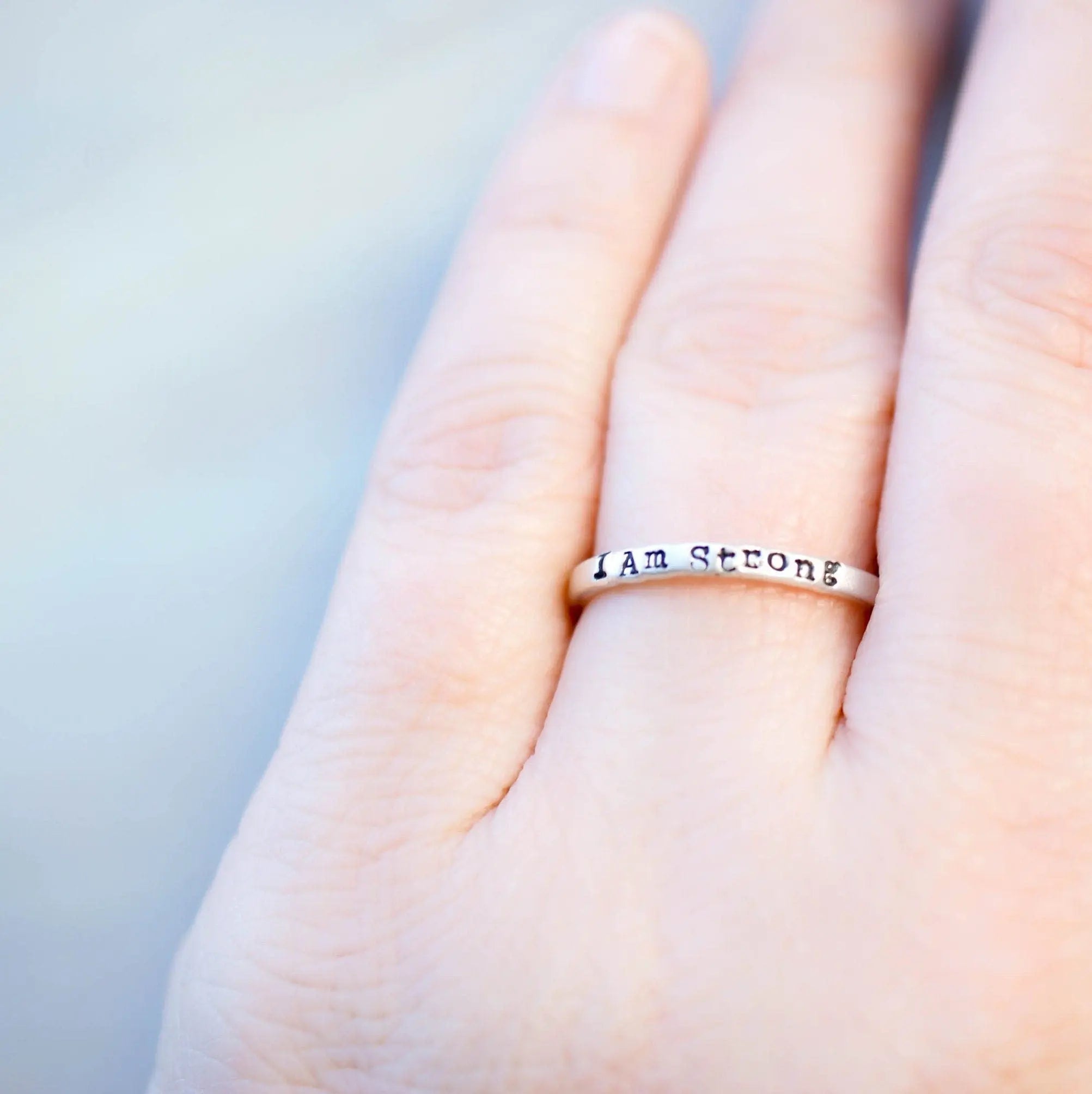 Sterling Silver stacking ring handstmaped with I Am Strong on hand