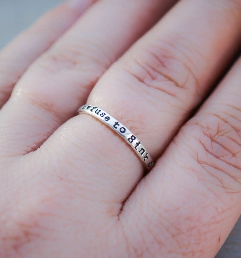 Sterling silver ring handstamped with Refuse to sink on hand