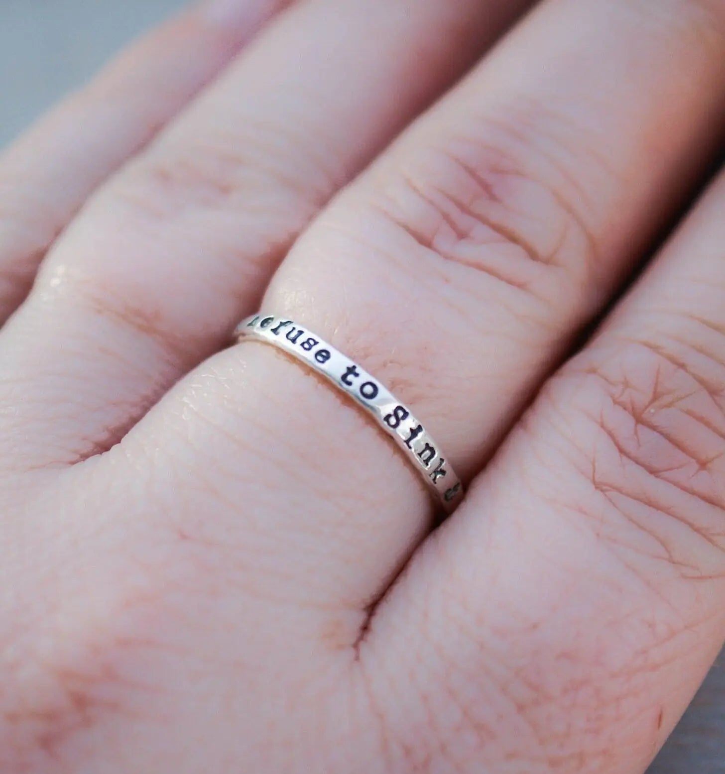 Sterling silver ring handstamped with Refuse to sink on hand