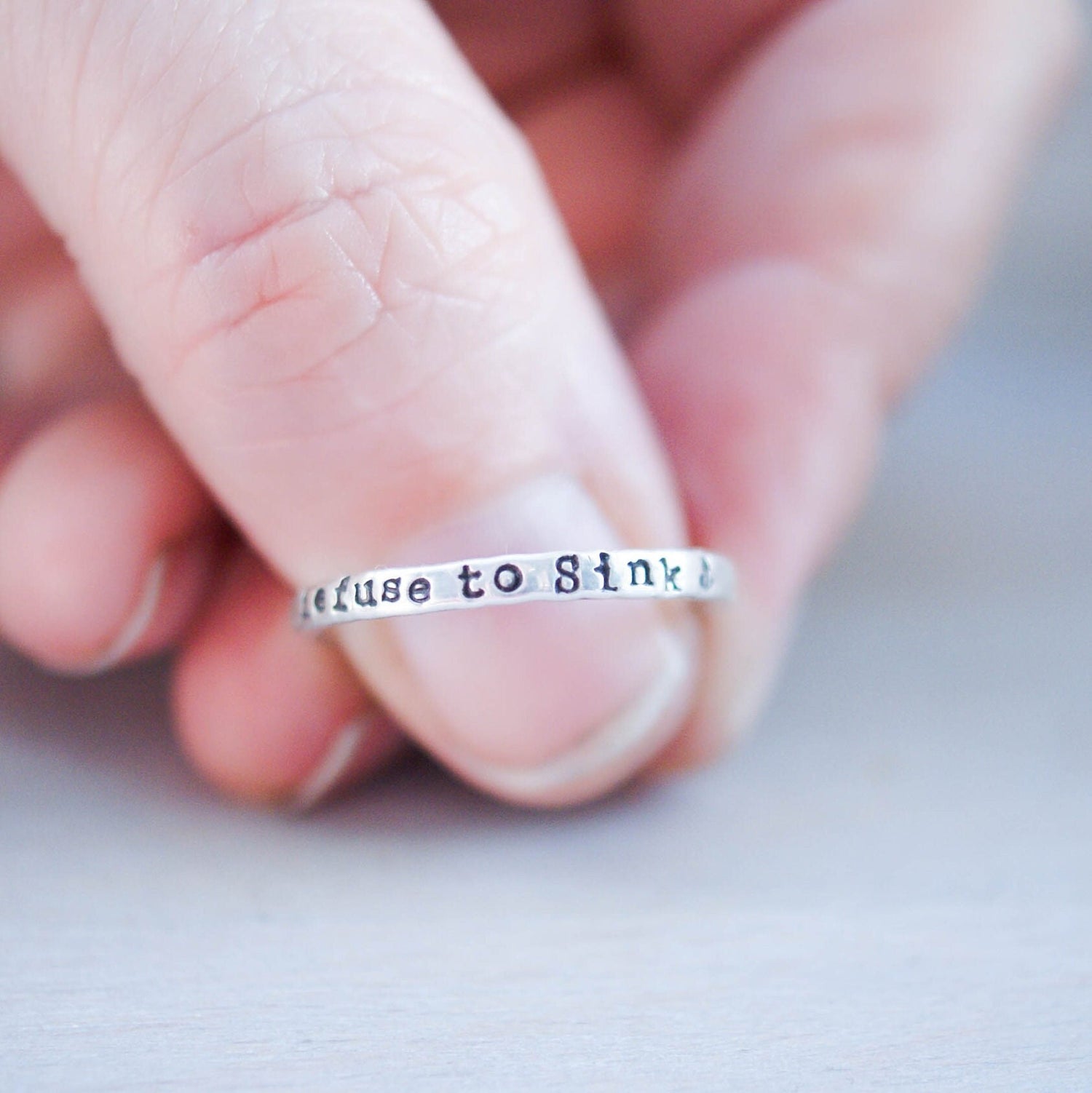 Sterling silver ring handstamped with Refuse to sink on thumb
