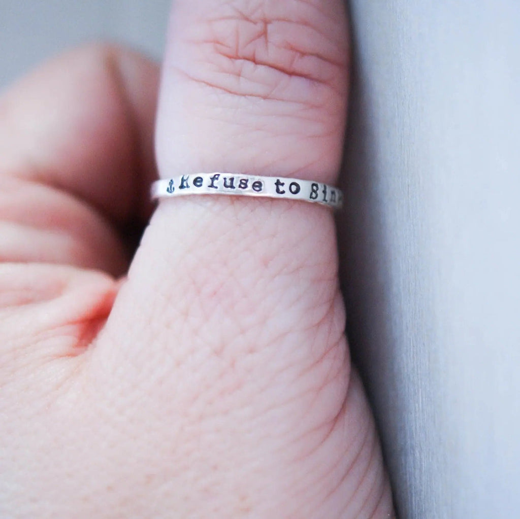 Sterling silver ring handstamped with Refuse to sink on thumb
