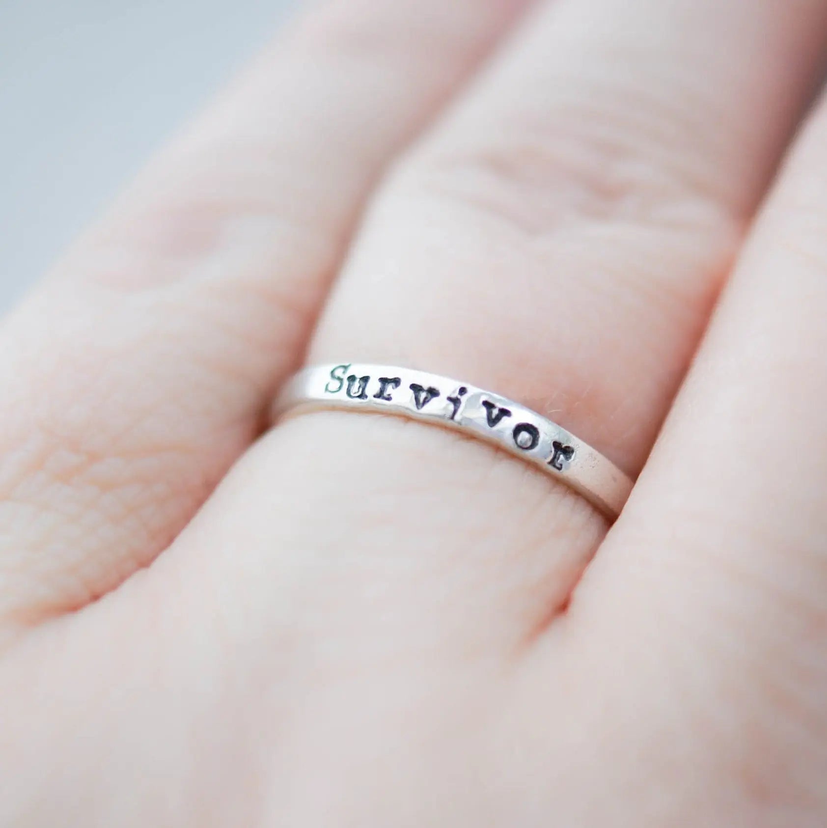 Sterling silver ring stamped with Survivor on hand
