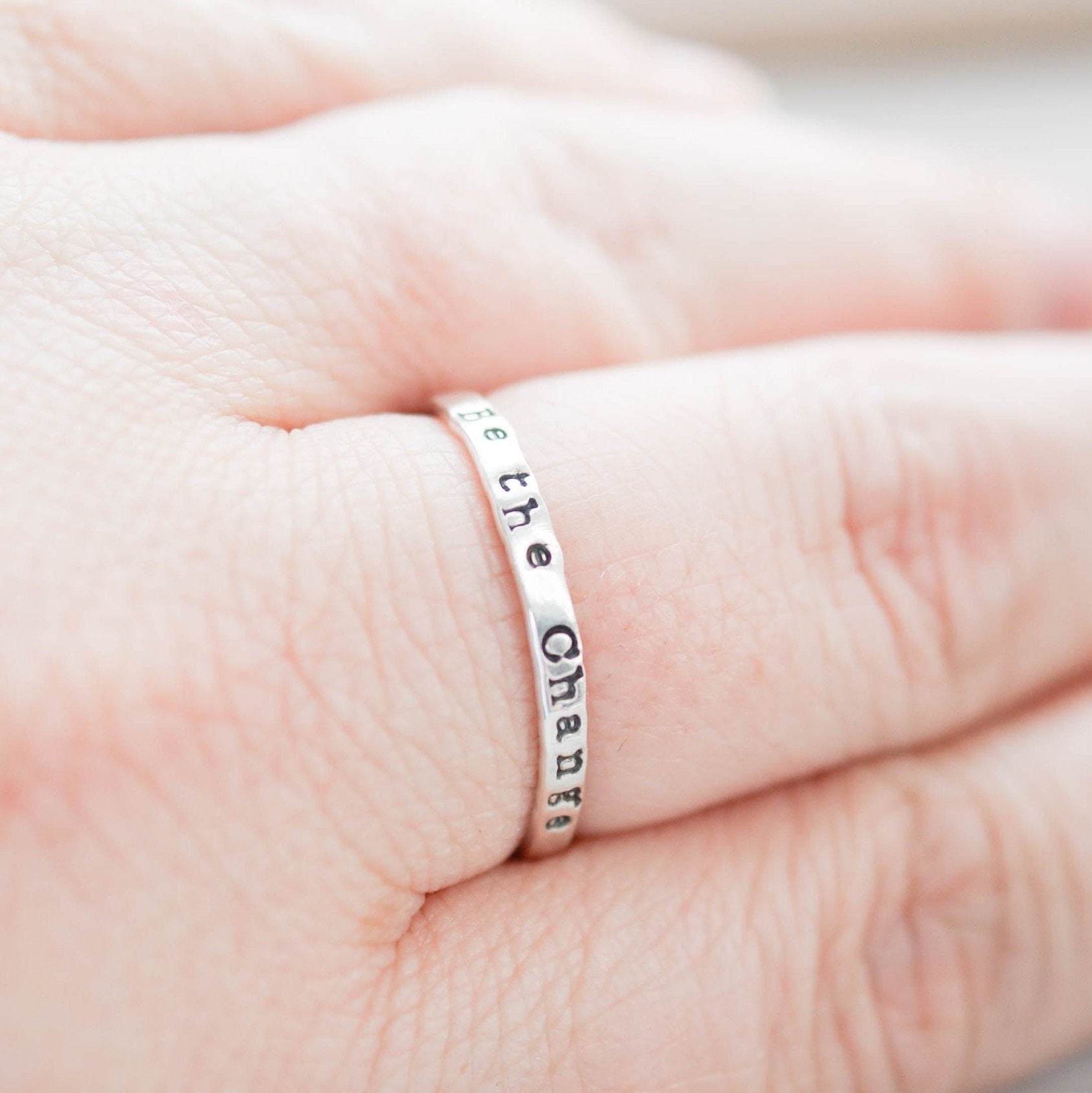 Skinny Stacking Ring handstamped with Be the Change in Sterling Silver on hand