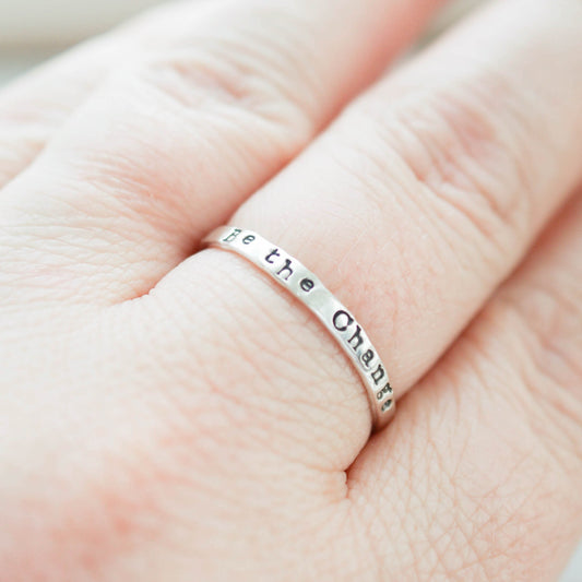 Skinny Stacking Ring handstamped with Be the Change in Sterling Silver on hand