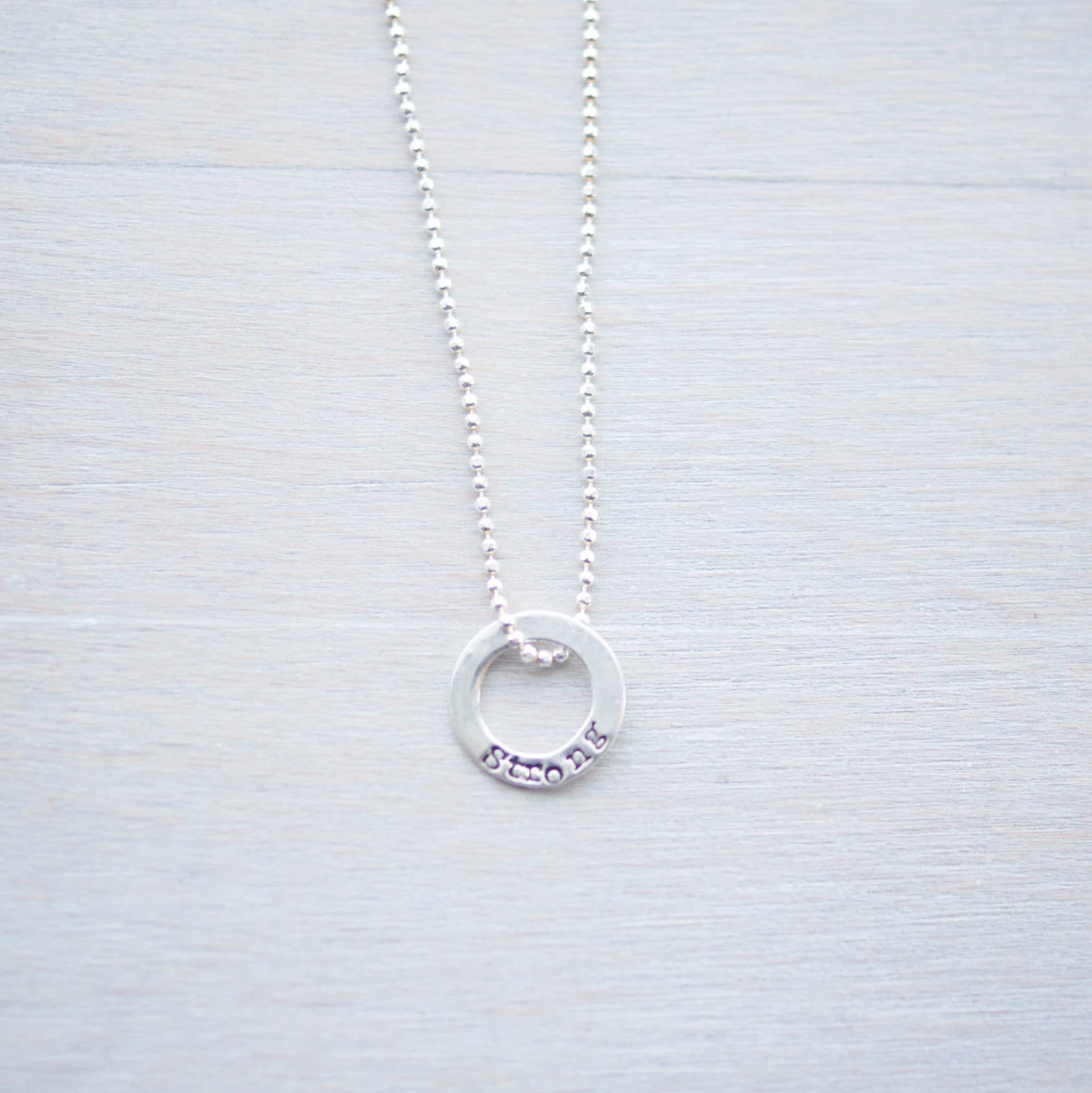 Sterling silver tiny circle stamped with Strong necklace