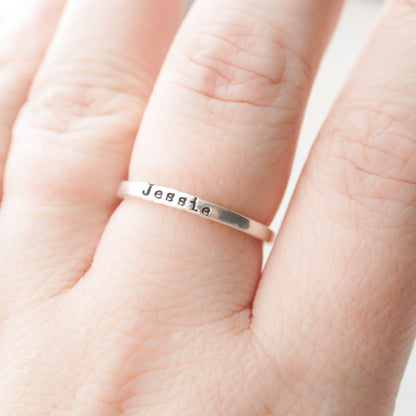 Sterling silver ring stamped with a personalized name on hand