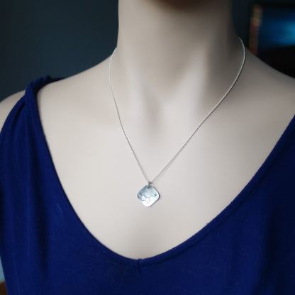 Sterling silver diamond shape necklace stamped with serotonin molecule on neck