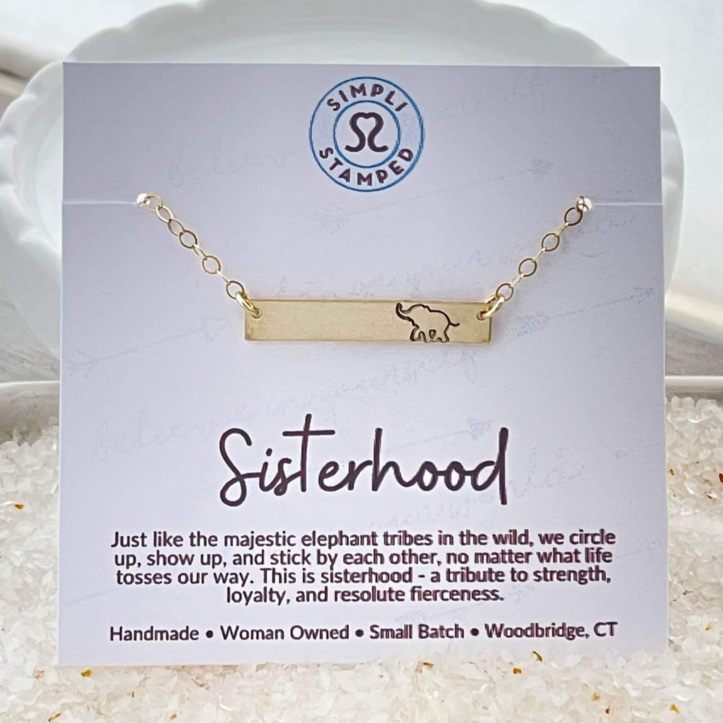 Gold bar necklace with elephant stmaped on it on card describing sisterhood