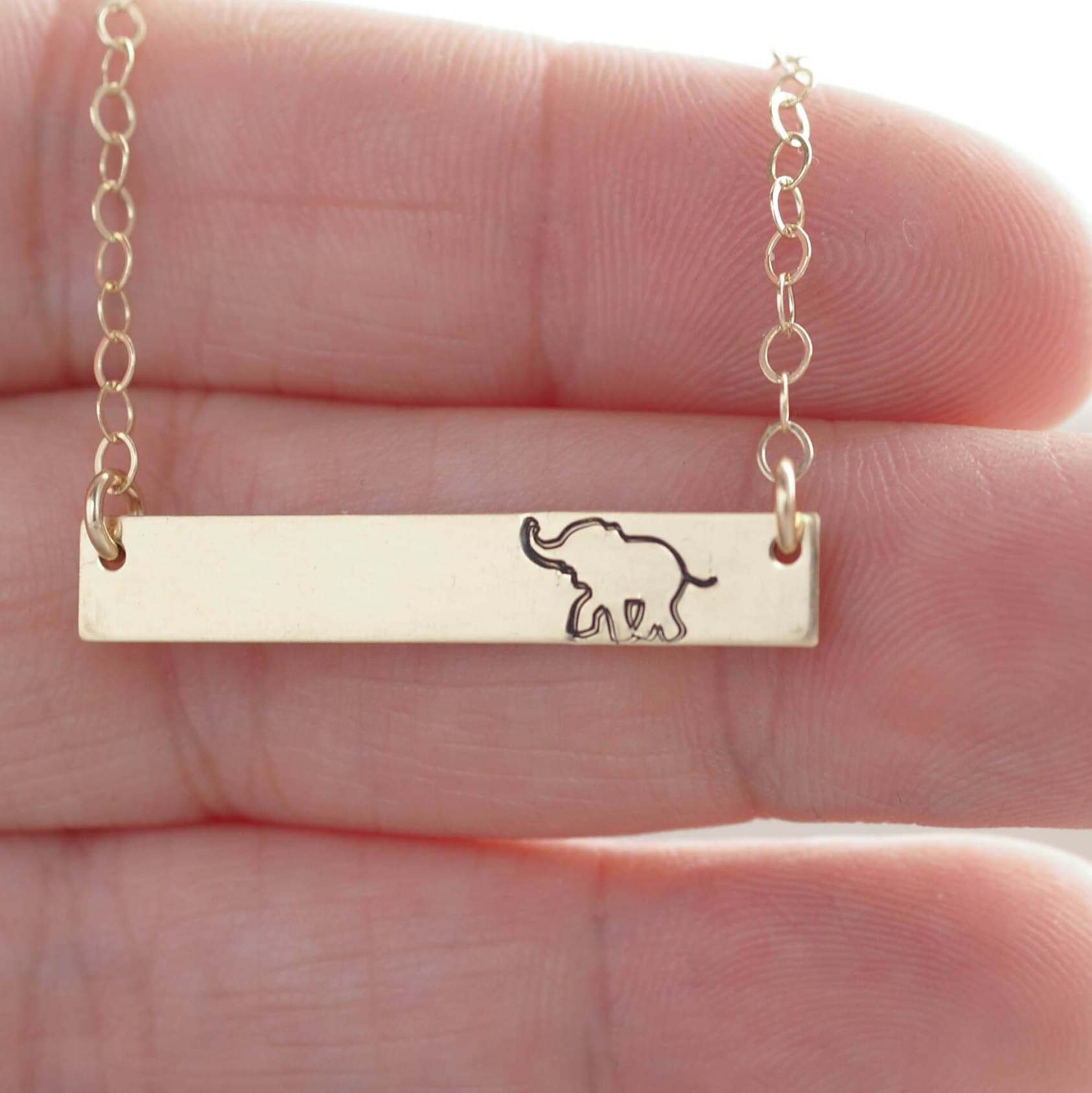 Gold bar neckalce stamped with elephant on hand